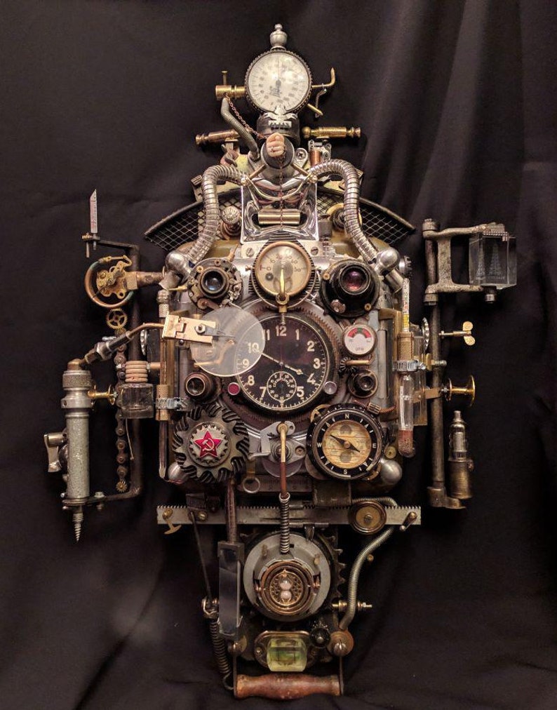 May include: A steampunk-style clock with multiple gears, dials, and gauges. The clock face has Roman numerals and a red star. The clock is made of metal and has a distressed finish.