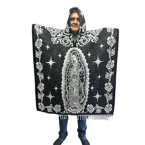 May include: Black hooded poncho with a white image of the Virgin Mary and stars. The poncho has a fringe border.