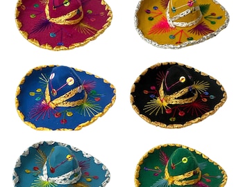 May include: Six miniature sombreros in magenta, yellow, blue, black, teal, and green. Each hat features a wide brim with metallic trim, a pointed crown, and decorative embroidery with colorful thread and small circular sequins throughout.