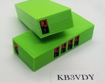 May include: Two bright green 3D printed boxes with red and black connectors. The top box is slightly angled and the bottom box has multiple connectors. The text "KB3VDY" is printed on a white label.