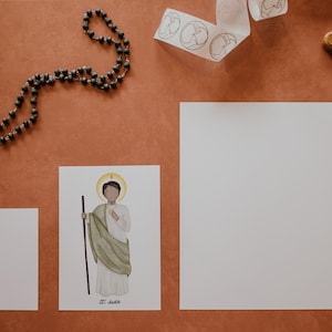 May include: A printable illustration of Saint Jude Thaddeus, a Catholic saint, with a halo and holding a staff. The illustration is on a white background with the words "St. Jude" printed below.