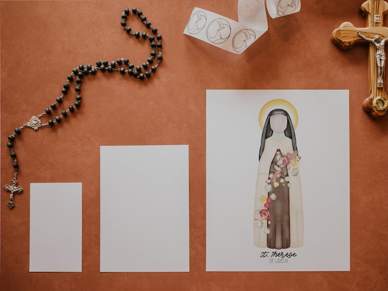 Puede incluir: Una impresi&oacute;n de arte imprimible blanca con una ilustraci&oacute;n de acuarela de Santa Teresa de Lisieux, una santa cat&oacute;lica. La ilustraci&oacute;n la muestra con un h&aacute;bito blanco con una faja marr&oacute;n y un ramo de rosas. El texto "Santa Teresa de Lisieux" est&aacute; impreso debajo de la ilustraci&oacute;n.