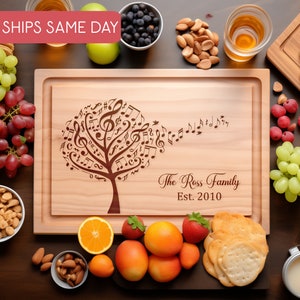 May include: A wooden cutting board with a design of a tree made of musical notes. The text "The Ross Family Est. 2010" is engraved on the board.