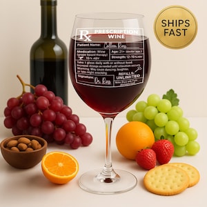 May include: A wine glass filled with red wine, featuring a prescription label with the text "Prescription Wine." The image includes a bottle of wine, grapes, oranges, strawberries, and crackers. A gold sticker reads "Ships Fast."