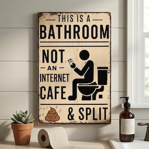 May include: A rectangular wooden sign with the text "THIS IS A BATHROOM NOT AN INTERNET CAFE & SPLIT". The sign features a black silhouette of a person on a toilet using a phone, and a cartoon poop emoji.