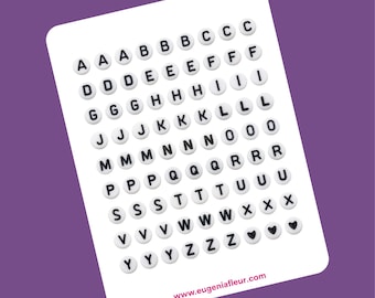 May include: White sticker sheet with black letters A through Z and two hearts. The letters are arranged in alphabetical order in rows. The sticker sheet has the text "www.eugeniafleur.com" at the bottom.