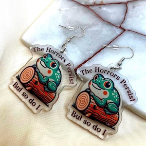 Los horrores persisten, pero yo también. Lindos pendientes colgantes de rana de dibujos animados sobre un tronco, de moda, hechos a mano, hipoalergénicos, de plata y oro.