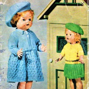 May include: Two dolls wearing knitted outfits and berets. The doll on the left is wearing a blue dress and beret, while the doll on the right is wearing a yellow sweater and green skirt and beret. The dolls are standing in front of a toy house.