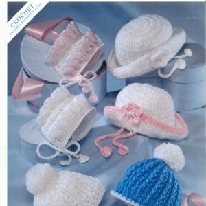 May include: Five crocheted baby hats in different styles and colors. The hats are white, pink, blue, and have different textures and embellishments. The hats are displayed on a light blue background.