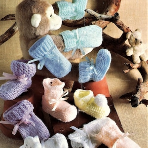 May include: A collection of knitted baby booties in various colors, including pink, blue, white, and purple. The booties have ribbon ties and some have pom-poms.