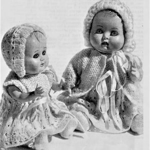 May include: Two crocheted dolls wearing bonnets. The dolls are dressed in white crocheted dresses. The doll on the left is sitting with her legs crossed. The doll on the right is sitting with her legs extended.