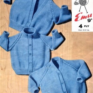Op de afbeelding: Drie blauwe gebreide vesten voor baby's of peuters. De vesten zijn gemaakt met een 4-draads garen en hebben een knoopsluiting. Het patroonnummer is 988. Emu 4 Ply garen wordt vermeld op het etiket.