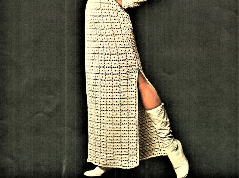 May include: A long, white crochet dress with a side slit and a geometric pattern. The dress is worn with white boots.