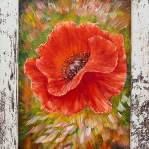 Puede incluir: Pintura al óleo de una vibrante flor de amapola roja en plena floración, sobre un fondo de pinceladas verdes, amarillas y rosas. La obra está enmarcada en un marco de madera blanca envejecida.