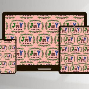 以下が含まれることがあります： ピンクの背景に、緑のリースの中に「JOY」の文字と「to the world」の言葉が入った、マネージャーの繰り返しパターンがあります。このパターンは、ラップトップ、タブレット、携帯電話の画面に表示されています。