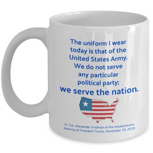 May include: White ceramic coffee mug with a blue quote that reads "The uniform I wear today is that of the United States Army. We do not serve any particular political party; we serve the nation."  The quote is attributed to Lt. Col. Alexander Vindman at the impeachment hearing of President Trump, November 19, 2019. A stylized image of the United States flag is below the quote.