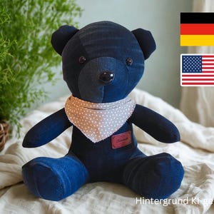 Pode incluir: Um urso de pelúcia de ganga feito à mão com um lenço cinza de bolinhas e uma pequena etiqueta vermelha. O urso tem remendos de ganga azul escuro e um nariz castanho. O fundo inclui uma planta e o texto "Hintergrund KI-generiert".