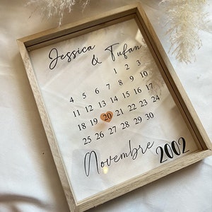 Peut inclure: Un calendrier encadré avec les noms Jessica & Tufan et la date du 20 novembre 2002 mise en évidence avec un cœur.