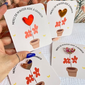 Peut inclure: Trois cartes avec un motif de fleur et de cœur. Chaque carte porte le texte "Merci de m'avoir aidé à grandir", qui se traduit par "Merci de m'avoir aidé à grandir". Les cœurs sont de couleurs différentes : rouge, or et rose avec des paillettes.