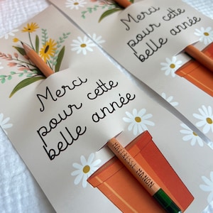 Może przedstawiać: Dwie kartki z kwiatowym wzorem i tekstem "Merci pour cette belle ann&eacute;e", co oznacza "Dziękuję za ten piękny rok". Każda kartka ma oł&oacute;wek wystający z doniczki z napisem "Maitresse Manon" na oł&oacute;wku.