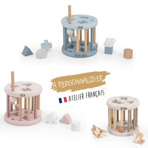 Peut inclure: Trois jouets en bois pour bébés avec des bases et des formes de couleurs différentes. Les jouets sont étiquetés avec les noms Eden, Lola et Dylan. Les jouets sont fabriqués en France.