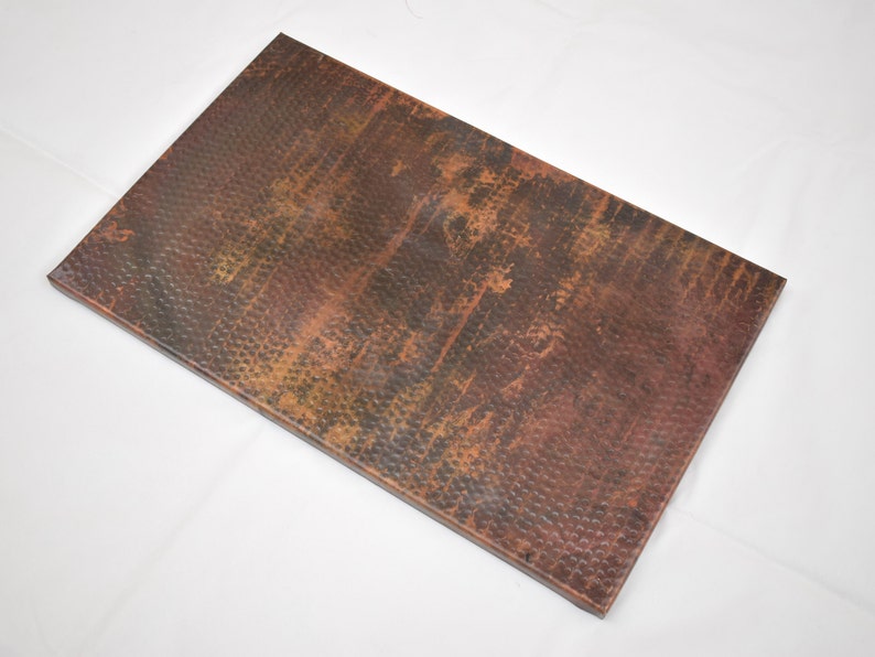 May include: A rectangular copper sheet with a hammered texture and a distressed finish. The sheet has a warm, reddish-brown color with hints of green and black.