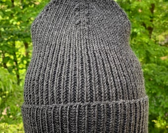 May include: A dark gray knitted beanie hat with a ribbed texture.