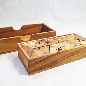 May include: A wooden puzzle game featuring a rectangular box and a separate lid. The puzzle pieces are triangular and adorned with colourful dots. The box and lid are crafted from light brown wood.
