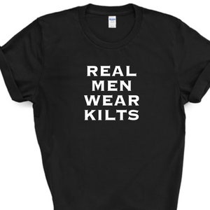 Peut inclure: T-shirt noir avec un texte blanc qui dit "REAL MEN WEAR KILTS".