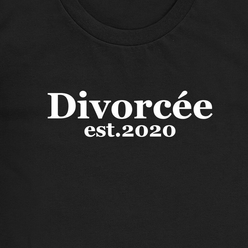 May include: Black t-shirt with the white text "Divorc&eacute;e est.2020" printed across the front. The text is in a bold, sans-serif font. The shirt has a crew neck.