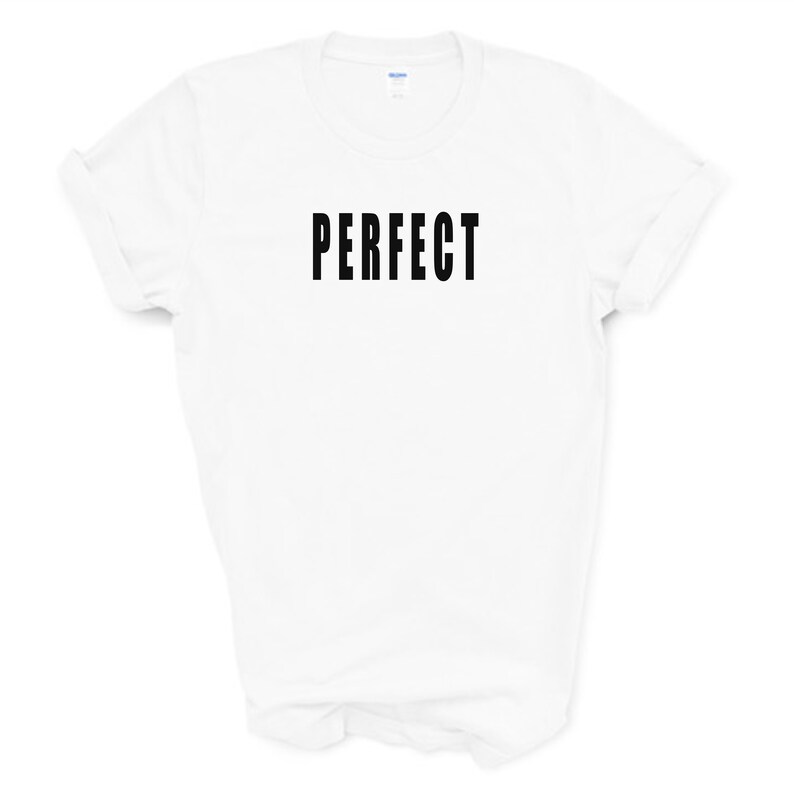 Puede incluir: Camiseta blanca con la palabra "PERFECT" impresa en negro en la parte delantera.