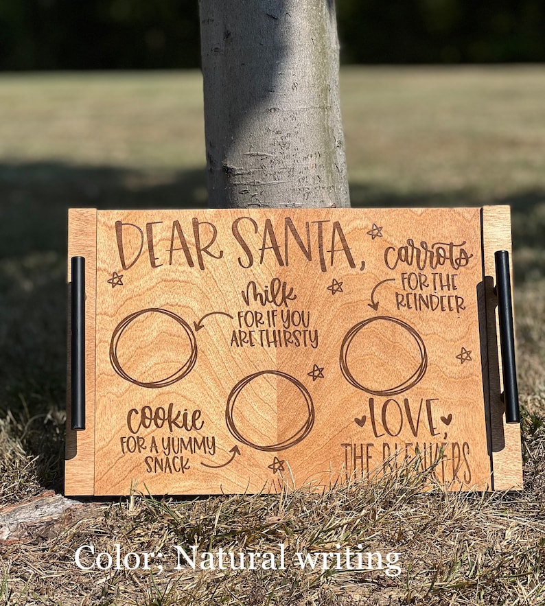 May include: A wooden tray with a "Dear Santa" message and three circles for placing treats. The circles are labeled "carrots for the reindeer", "milk for if you are thirsty", and "cookie for a yummy snack". The tray also has the text "Love, The Beavers" and is decorated with stars.
