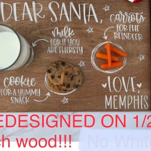 May include: A wooden tray with the words "Dear Santa" written on it. The tray is decorated with white paint and includes a glass of milk, cookies, carrots, and the words "Love, Memphis".