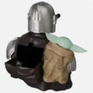 K&ouml;nnte beinhalten: Eine dekorative Figur, die einen silberfarbenen, behelmten Charakter in dunkler R&uuml;stung zeigt, mit einer kleinen, hellgr&uuml;nen, gro&szlig;ohrigen Kreatur in einer beigefarbenen Tasche an der Seite. Die Figur verf&uuml;gt &uuml;ber einen ausgeh&ouml;hlten Mittelteil.