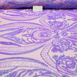 May include: Purple iridescent sequins on a light pink mesh fabric with a damask pattern. The sequins are sewn in a floral design.