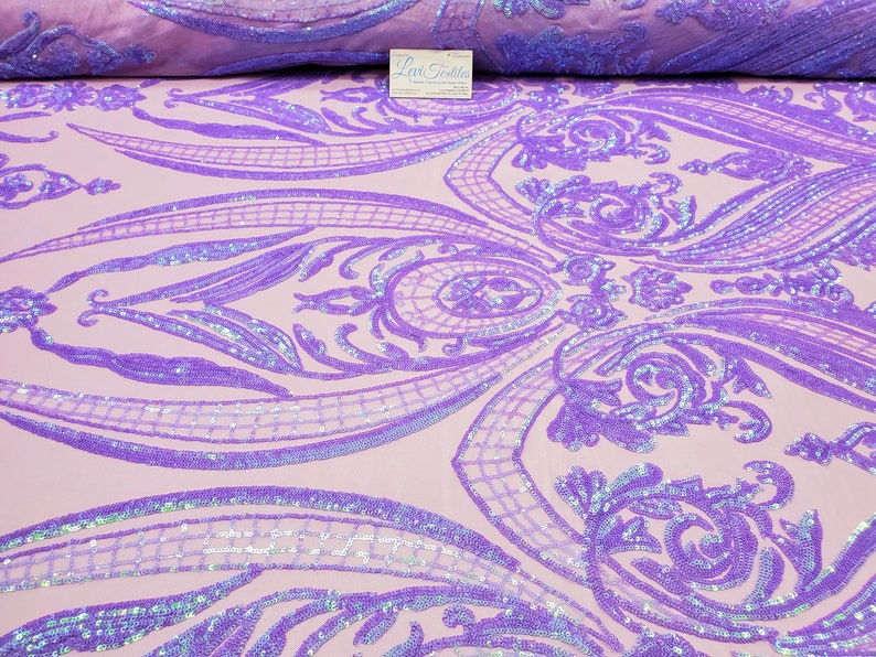 May include: Purple iridescent sequins on a light pink mesh fabric with a damask pattern. The sequins are sewn in a floral design.