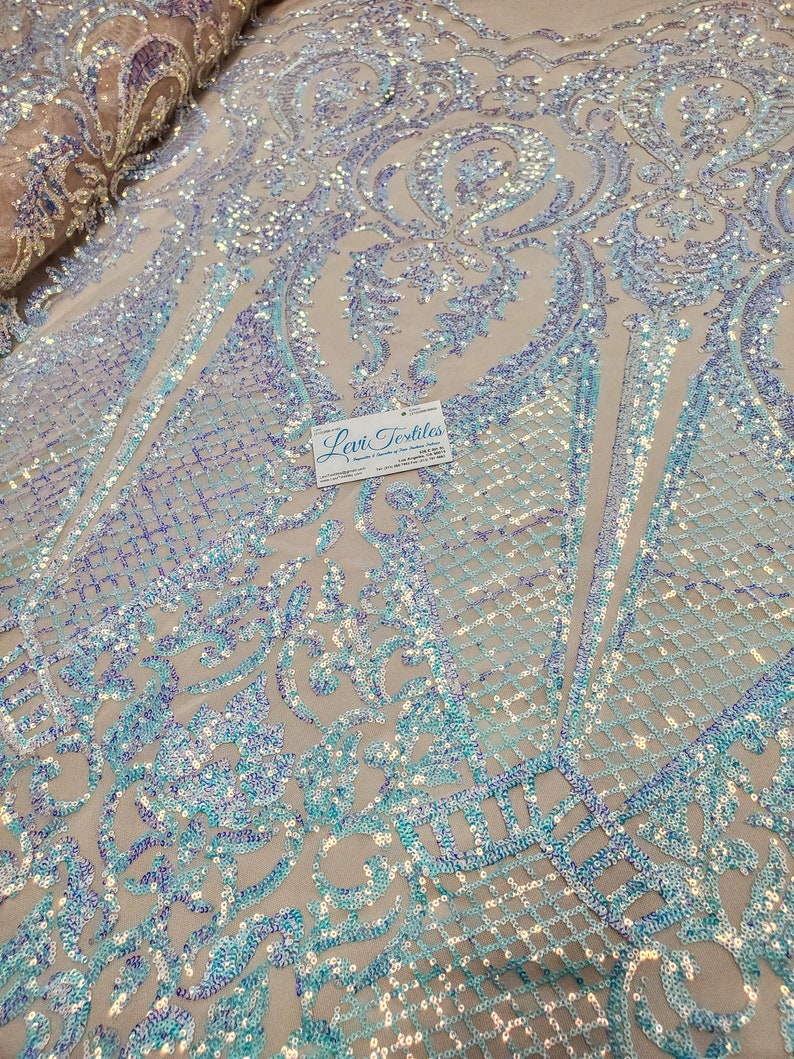 May include: Pale blue iridescent sequins on a sheer mesh fabric with a damask pattern. The fabric is perfect for creating a glamorous and sparkly look for dresses, tops, and other garments.