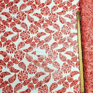 May include: Red and orange floral fabric with a white background. The fabric is made of sequins and has a shimmery finish. The fabric is sold by the yard and is perfect for making dresses, skirts, and other garments.