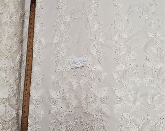 Tissu de dentelle de broderie ivoire avec applications 3D, perles, pierres et plumes d’autruche sur tissu de mariage de bal en maille