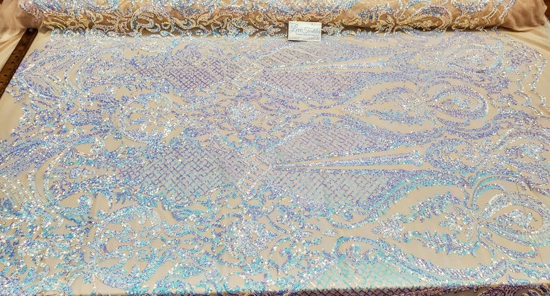 May include: White iridescent fabric with a floral pattern. The fabric is covered in sequins that shimmer in the light.