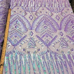 May include: Purple and silver iridescent sequins on a sheer mesh fabric. The sequins are arranged in a geometric pattern with a fringe border.