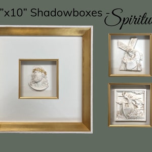 May include: Three 10"x10" shadowboxes with a gold frame and white matting. The shadowboxes feature religious scenes, including a depiction of Jesus with a crown of thorns, Jesus carrying the cross, and a scene of a boat with people on it.