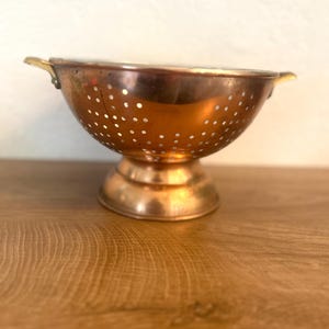 Puede incluir: Una tabla de cortar de madera hecha a mano con un acabado natural. La tabla presenta un borde vivo en un lado y una forma rectangular lisa. Mide aproximadamente 45 cm de largo y 30 cm de ancho.