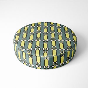 May include: A round, yellow and teal patterned floor cushion. The cushion has a geometric pattern of vertical lines and circles.
