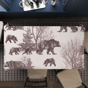 Peut inclure: Une nappe rectangulaire avec un motif répété d'ours bruns et d'arbres sur un fond beige clair. Le motif présente différentes tailles d'ours et des éléments forestiers, créant un thème rustique inspiré de la nature.