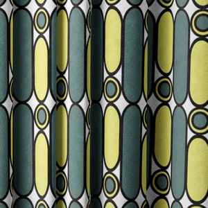 May include: A white fabric with a repeating pattern of yellow and teal ovals and circles. The fabric is folded in the center.