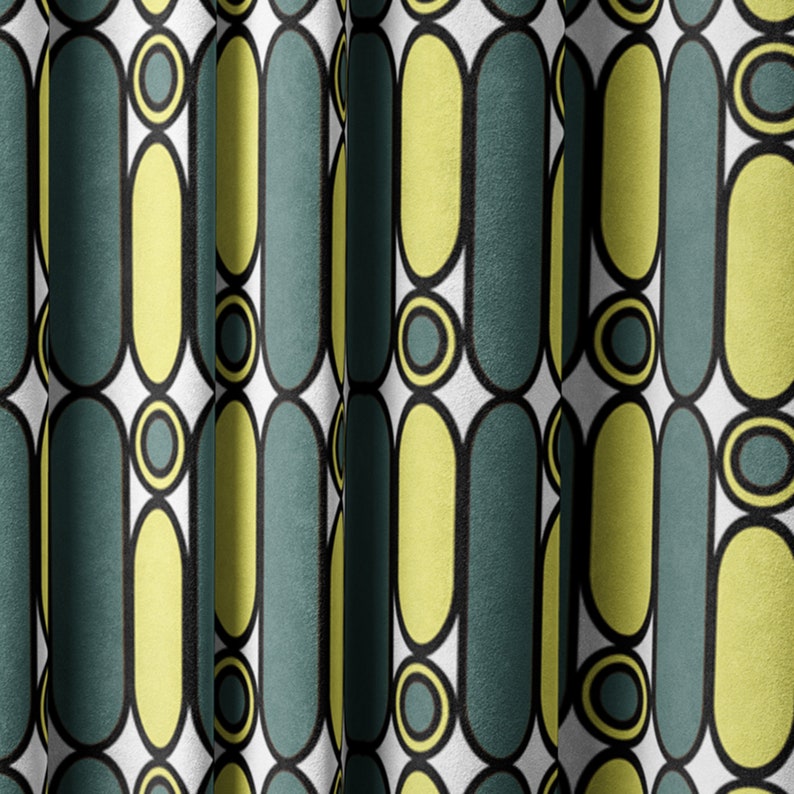 May include: A white fabric with a repeating pattern of yellow and teal ovals and circles. The fabric is folded in the center.