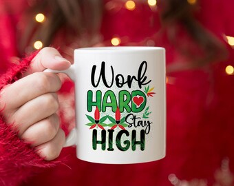 May include: White ceramic mug with a green and red graphic that says "Work Hard Stay High".