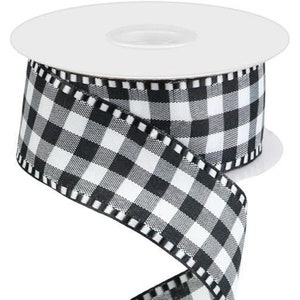May include: Black and white checkered ribbon with a white background and black squares. The ribbon has a stitched edge.