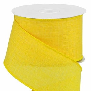 May include: A spool of bright yellow, 2.5 inch wide, wired ribbon. The ribbon is made of a textured, linen-like fabric.
